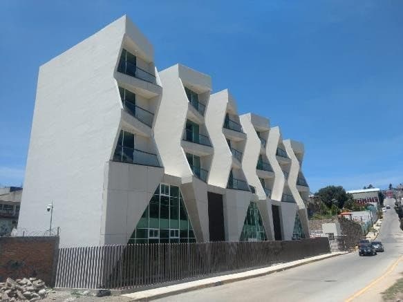 Fachada del albergue estudiantil: cinco niveles de volúmenes blancos escalonados con balcones